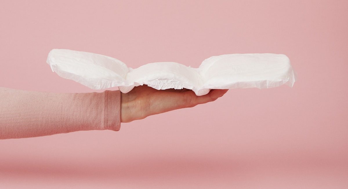 store efterfødselsbind fra momkind hånd holder et bind til efter fødsel som er foldet ud