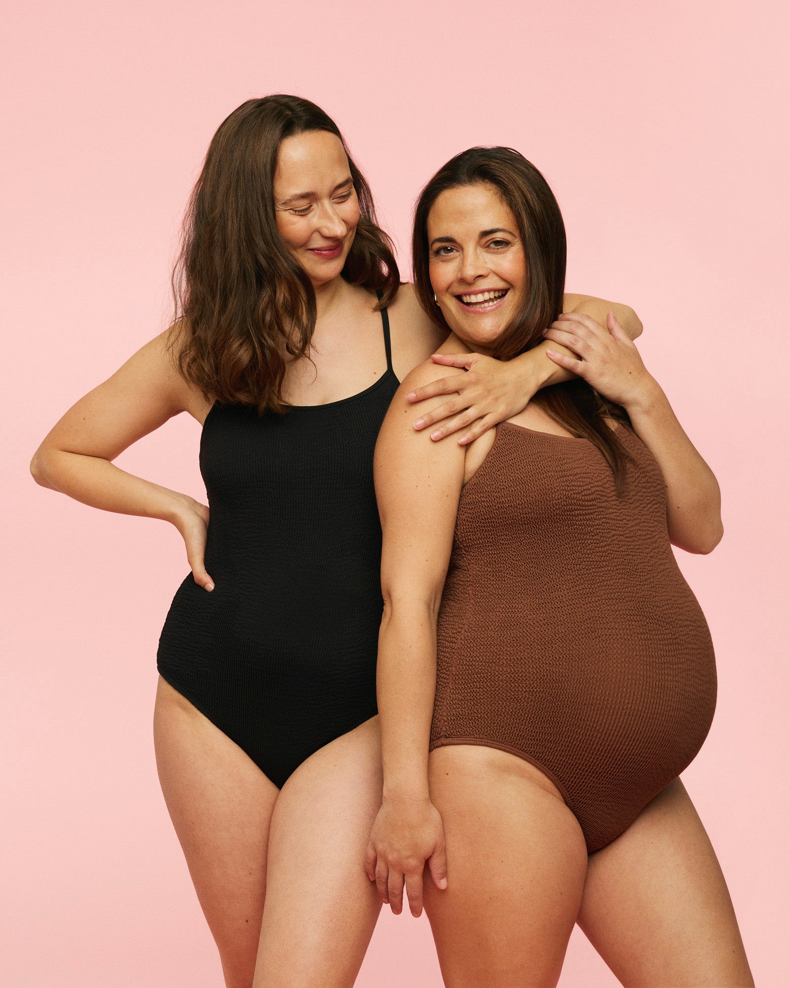 Billede af to gravide kvinder i en sort gravid badedragt og en brun gravid badedragt.