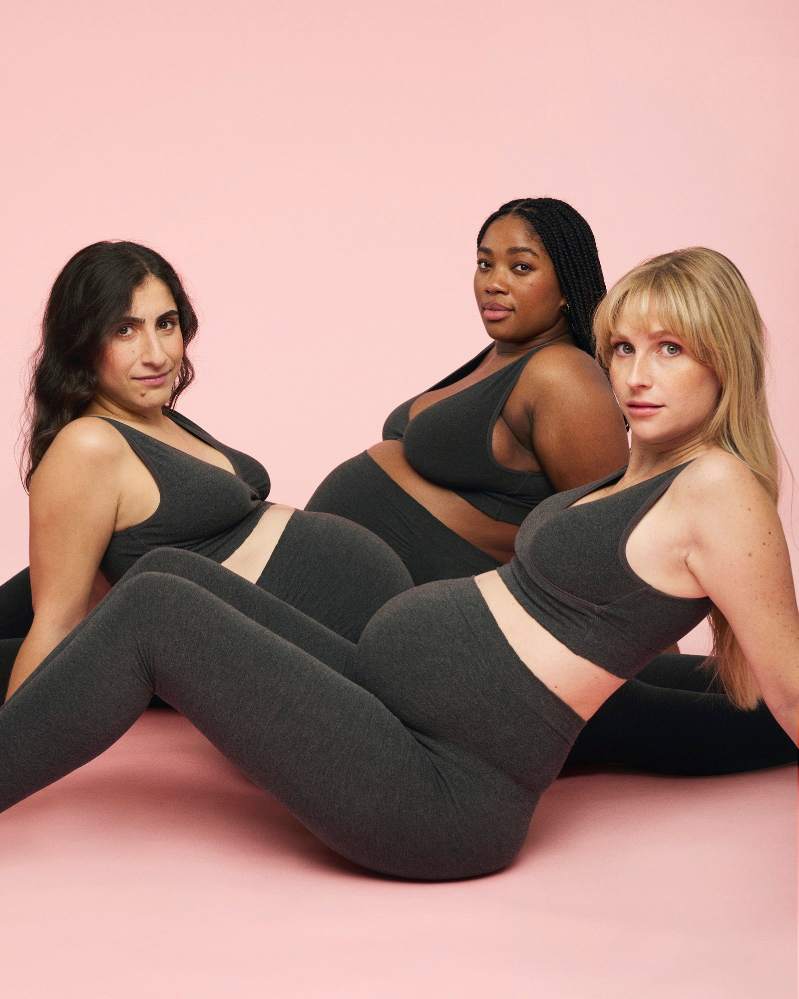 Tre kvinder er alle iført gravidleggings og crossover bra i farven charcoal / grå fra momkind. Leggings sidder helt over maven fordi der er godt med strech i.