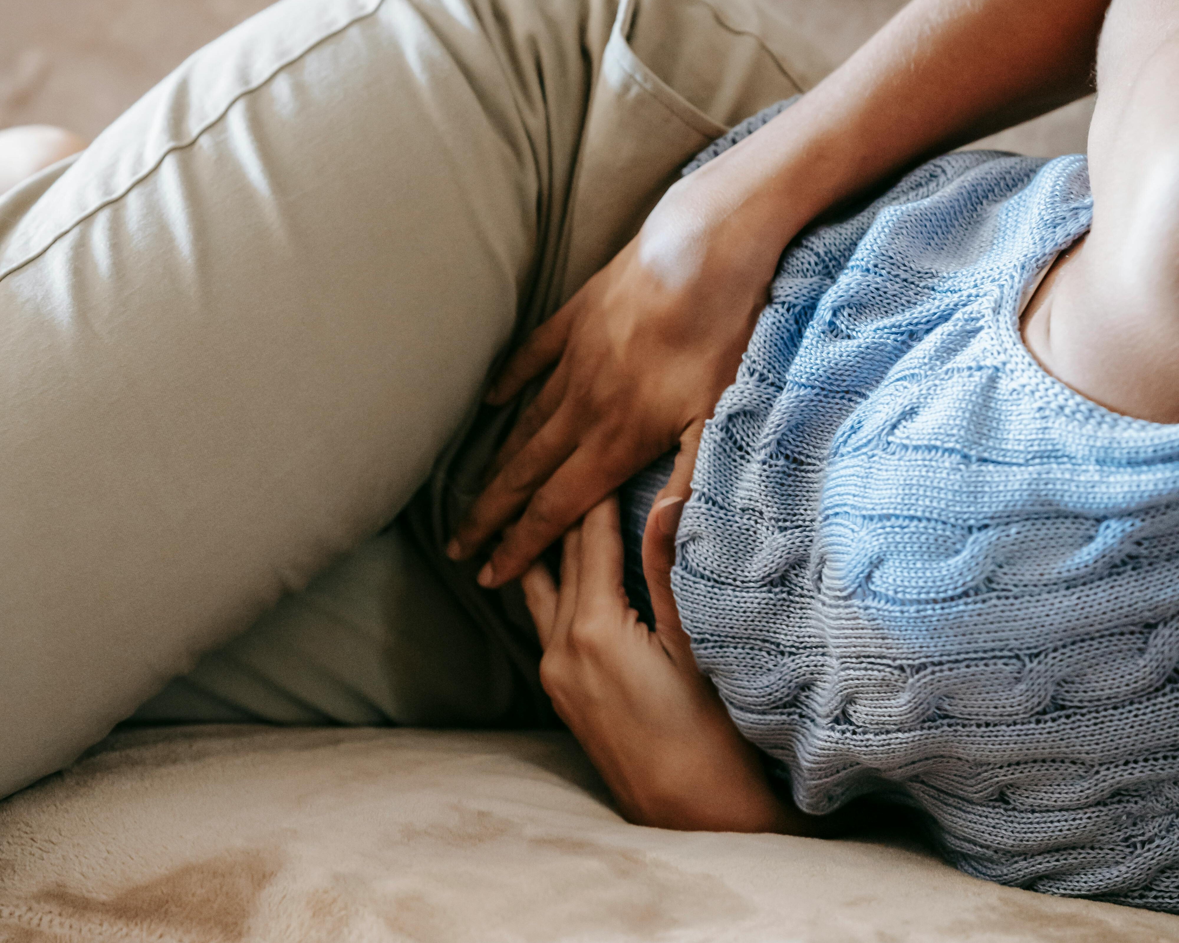 nærbillede af kvinde der ligger med hænderne på maven