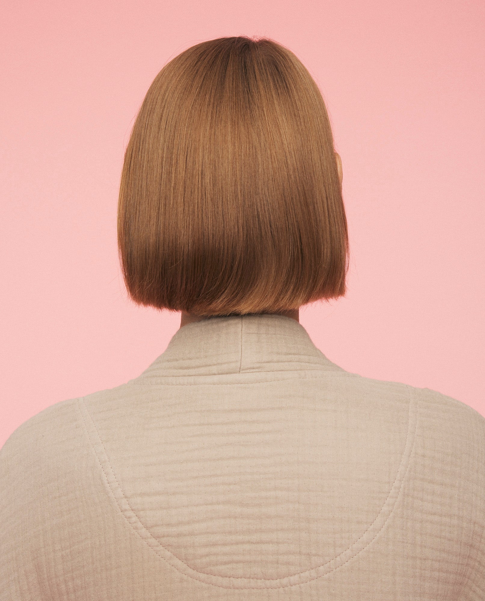 Nærbillede af kvinde som har momkind kind robe på. Billedet viser, hvordan kåben ser ud bagfra helt oppe ved ryg og nakke.