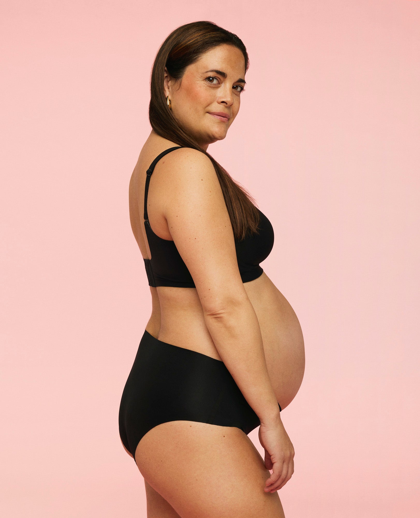 Gravid kvinde iført sømløse graviditetstrusser. Trussens pasform under taljen ses på billedet.