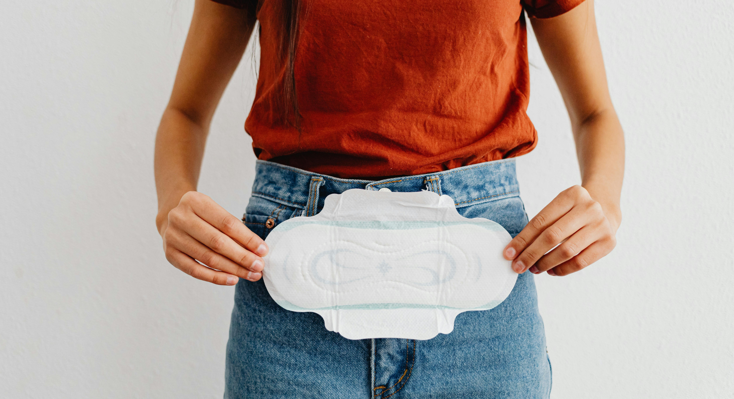 udebleven menstruation forsinket mens kvinde holder bind uden blod i hænderne foran kroppen