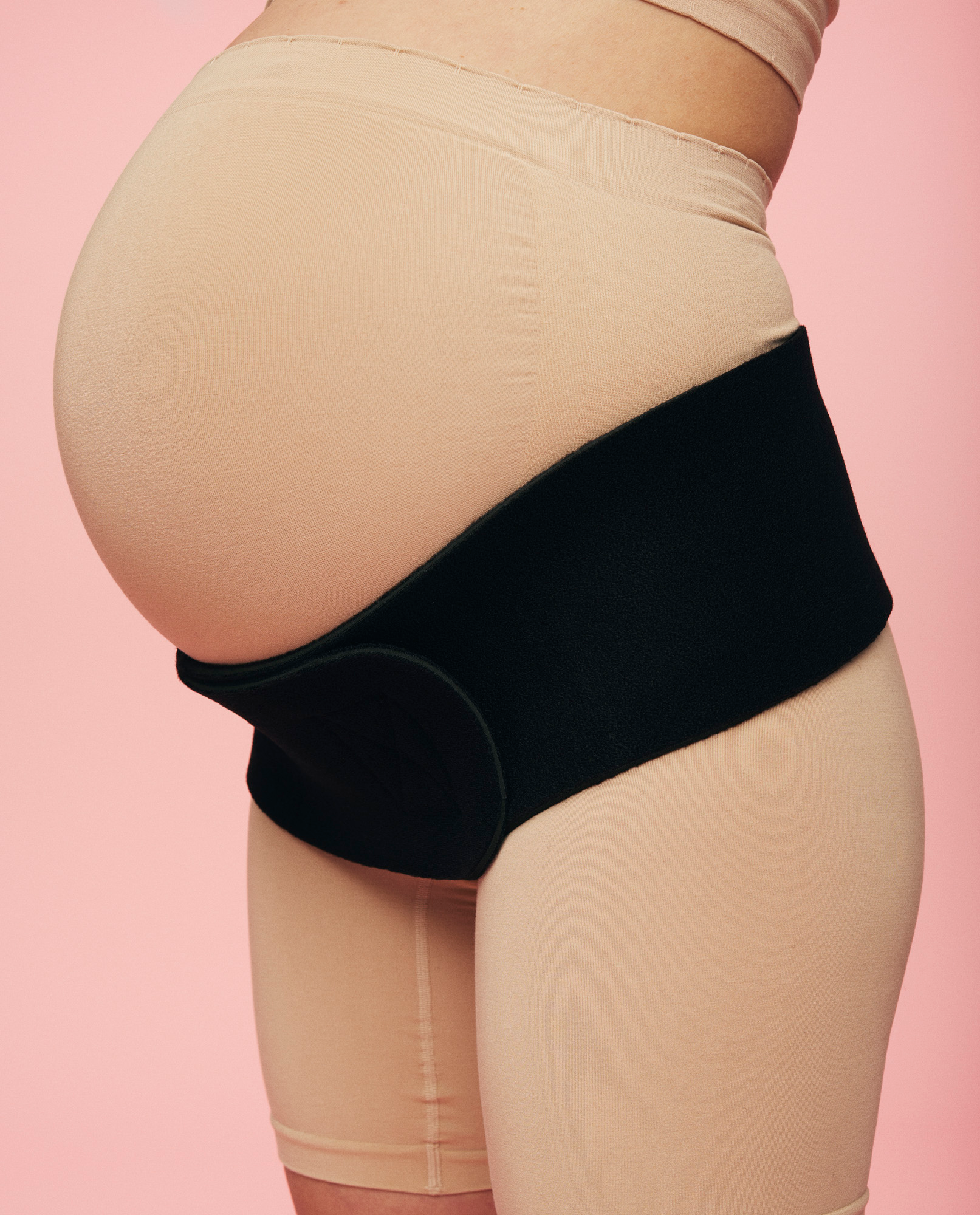 close up af gravid kvinde med bækkenløsning iført bækkenbælte fra momkind
