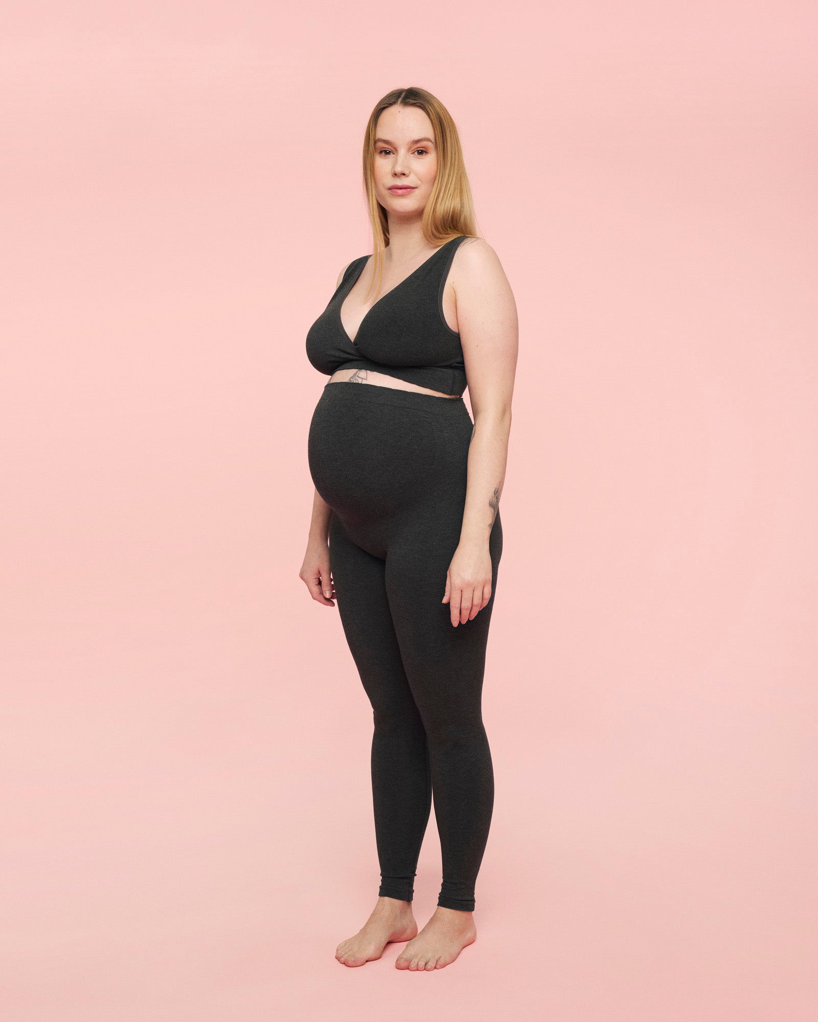 gravid kvinde iført bløde og støttende gravidleggings i grå fra momkind og grå crossover bh til gravide fra momkind