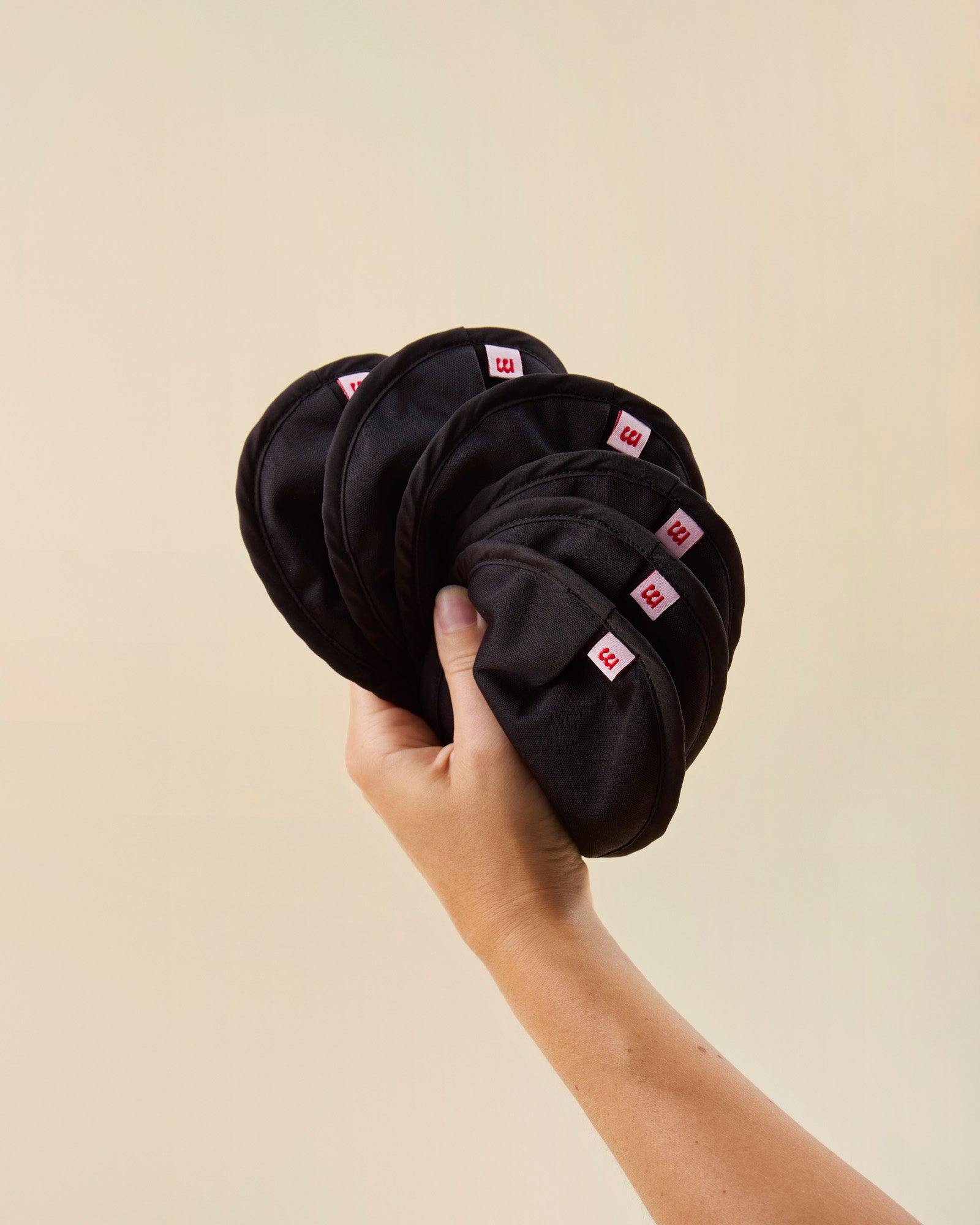 hånd holder 6 sorte ammeindlæg fra momkind