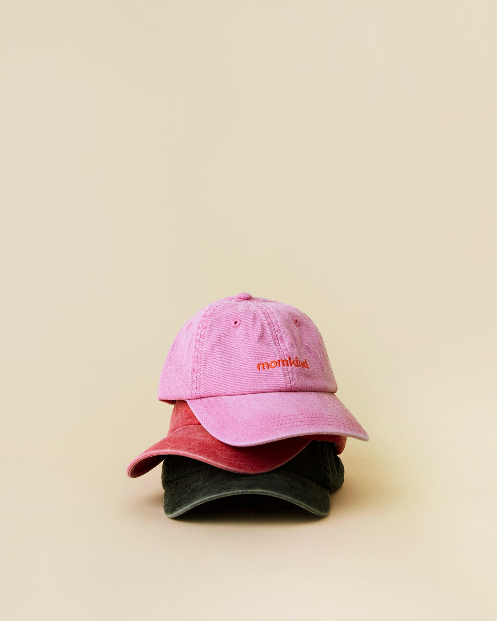 momkind cap I alle tre farver. Lyseroed, roed og sort. De er alle tre stablet ovenpå hinanden