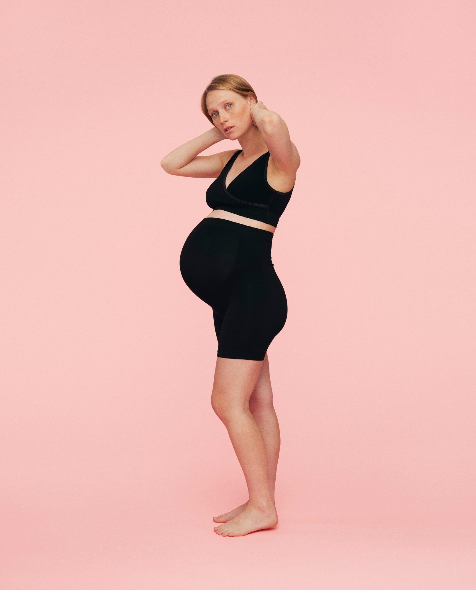 kvinde iført crossover bh i sort fra momkind og gravid shorts i sort fra momkind