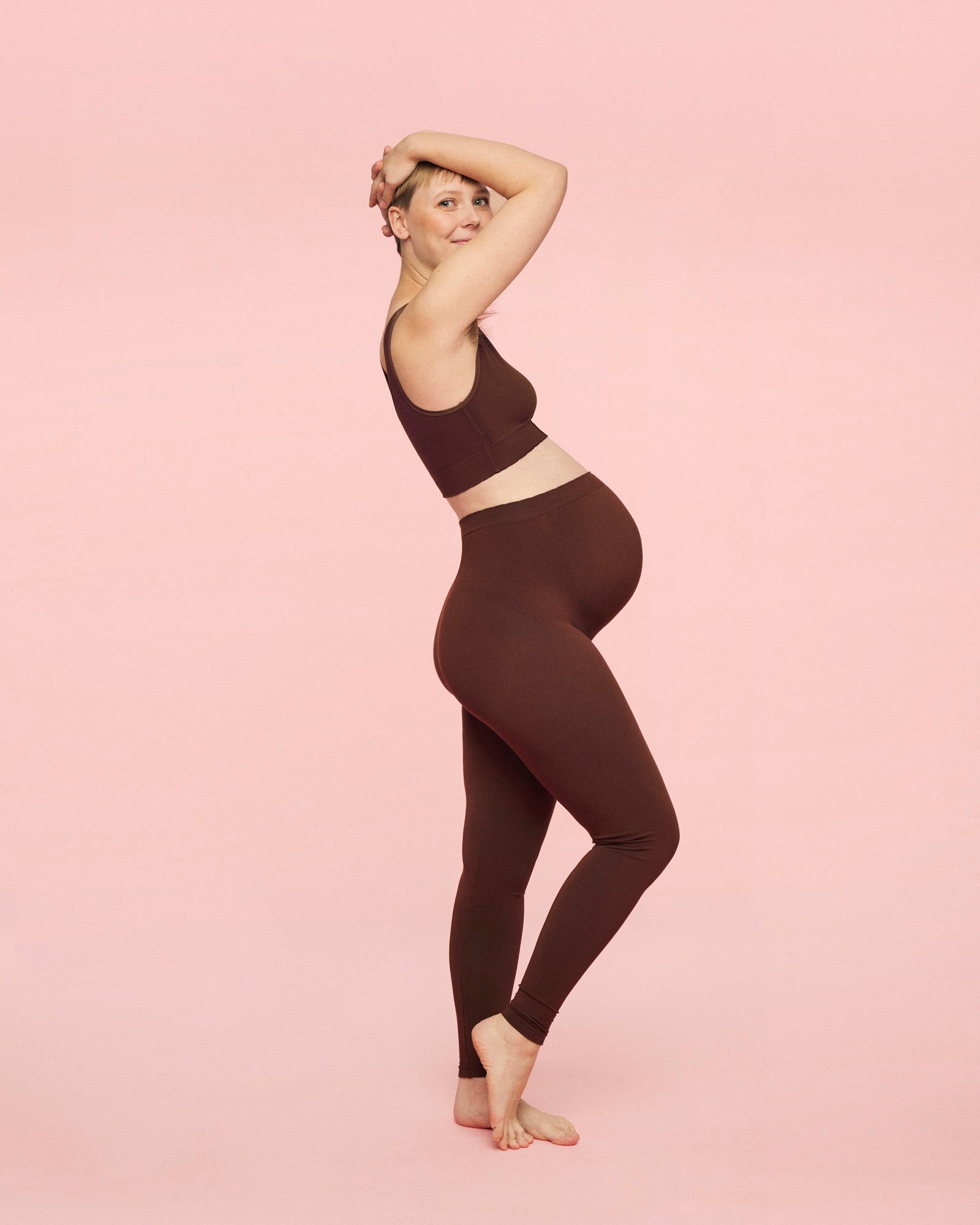 gravid kvinde iført gravid leggings i brun og crossover amme bh i brun fra momkind 