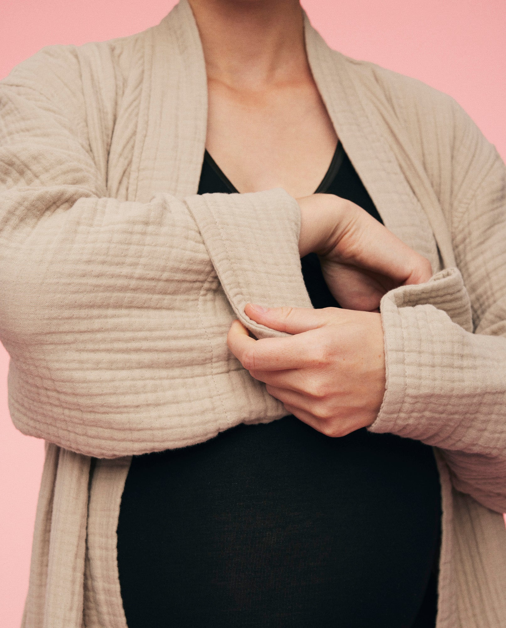 Nærbillede af gravid kvinde som har kind robe på fra momkind. Billedet viser ærmerne som kan foldes på morgenkåben. 