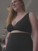 Kvinde iført hugwear shorts i sort samt amme bh fra momkind. 